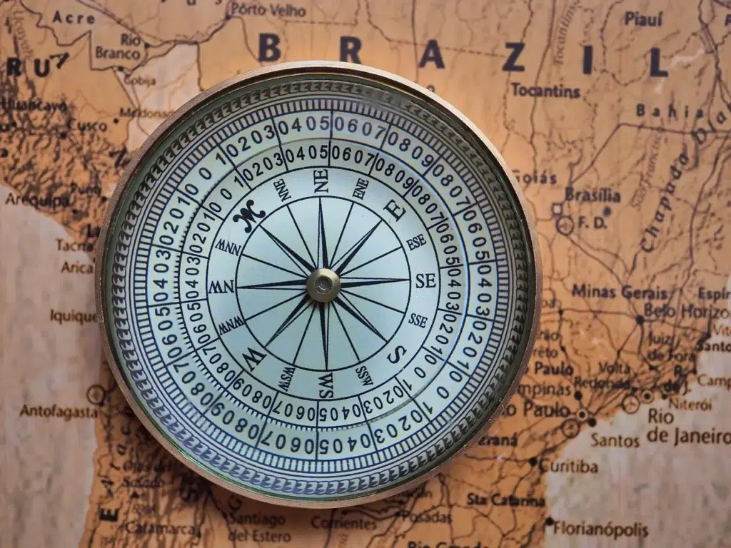 Brújula sobre mapa del mundo antiguo, que se ve América y el país de de Brasil